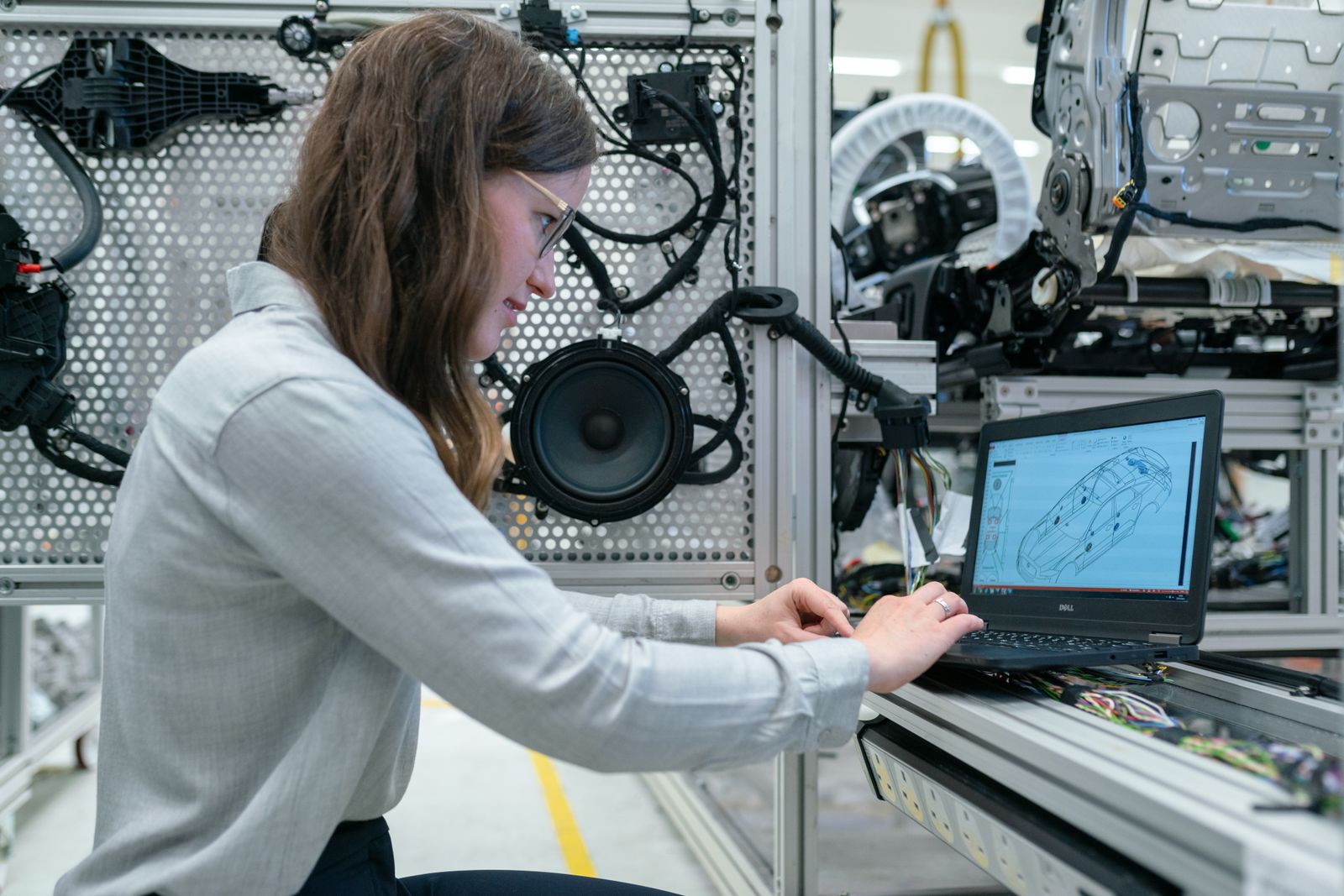 Ingénieure travaillant sur ordinateur portable devant un banc d'essai technique
